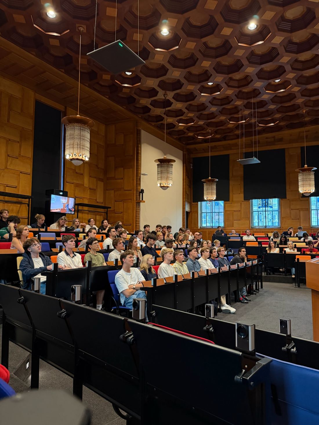 Students watching an online speaker event in a lecture hall
